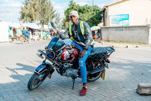 A motorcycle taxi rider waits for passengers on a bustling street in Nairobi, Kenya.